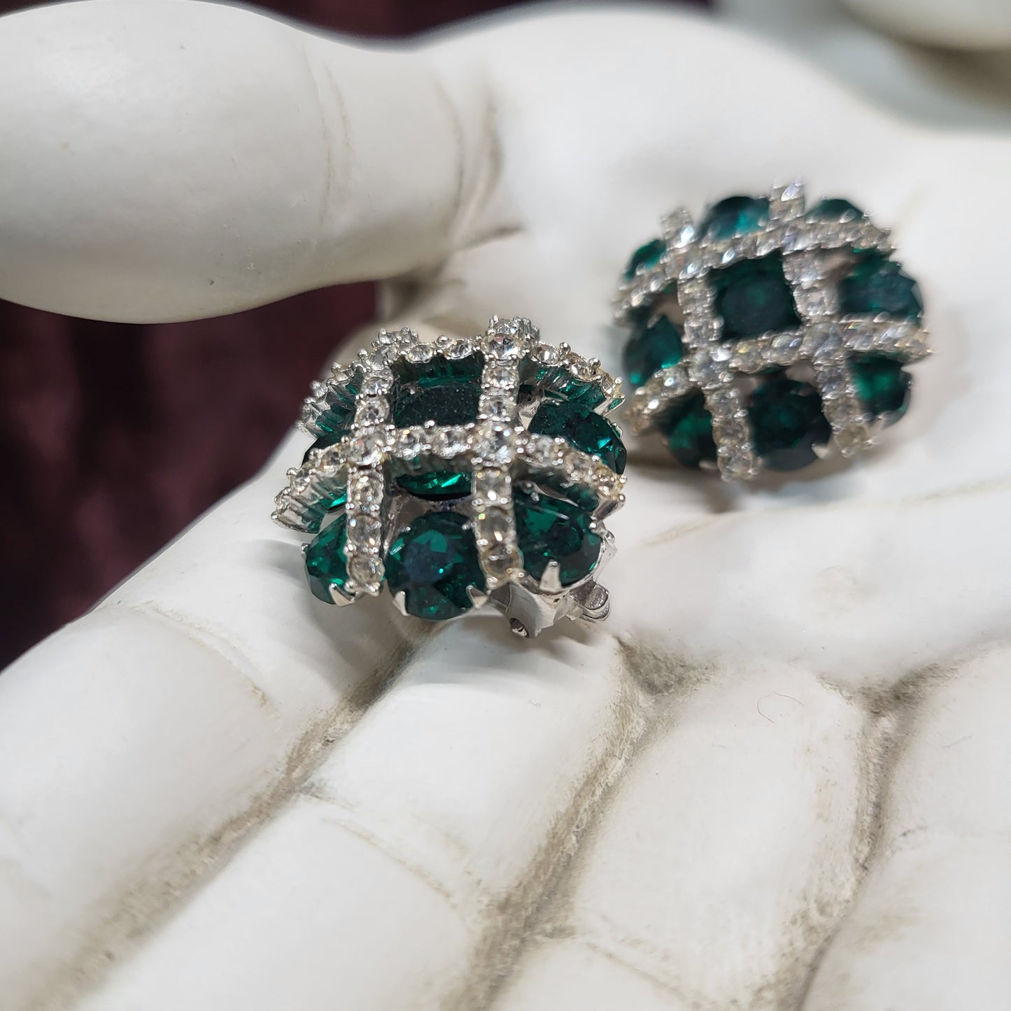 Pair of green gemstone earrings on a white surface