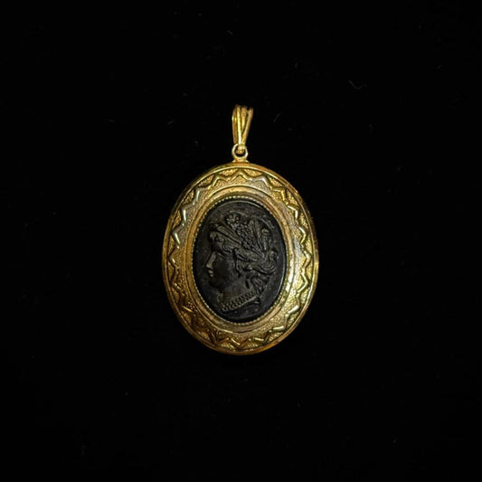 Gold pendant Cameo with a black center on a black background