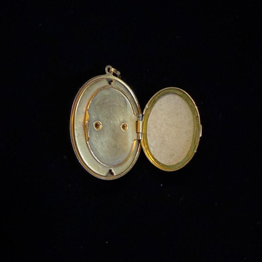 Gold locket with two open sides on a black background