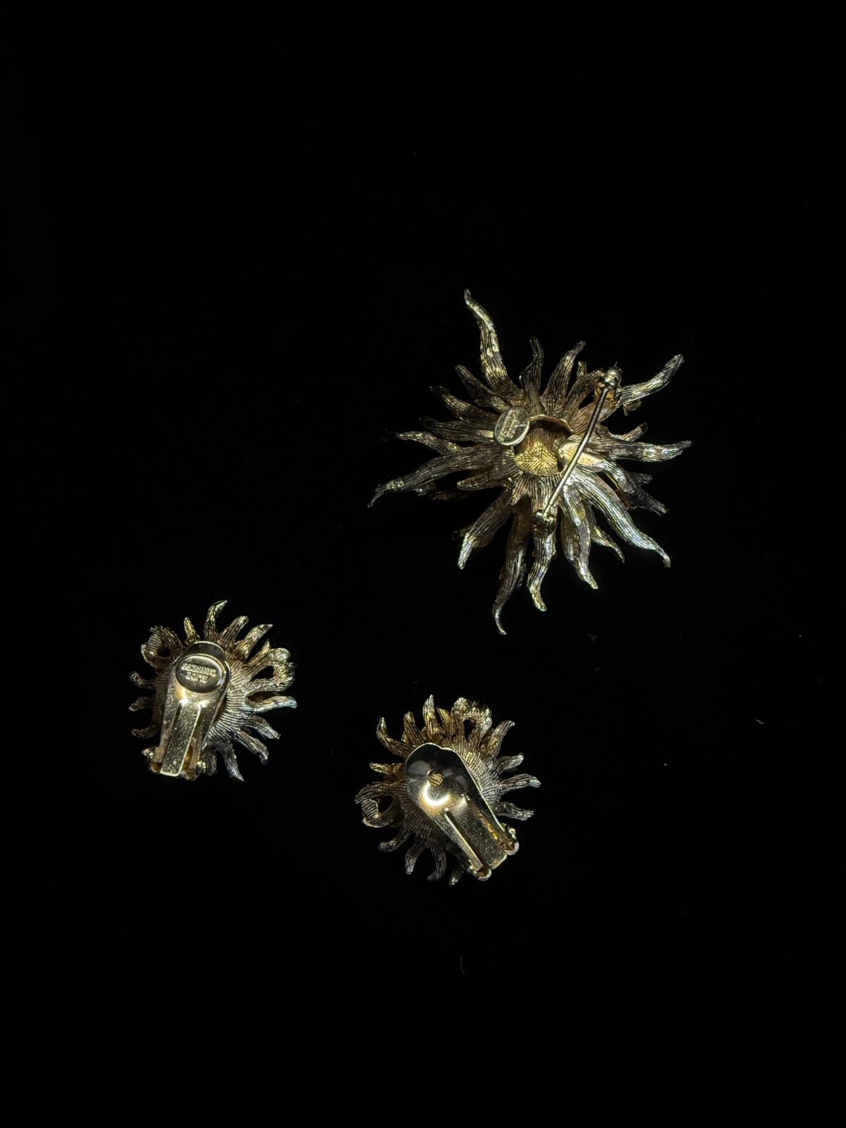 Three metallic star-shaped objects on a black background