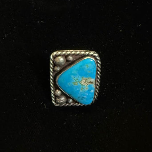 Small square turquoise stone ring silver border on a black background