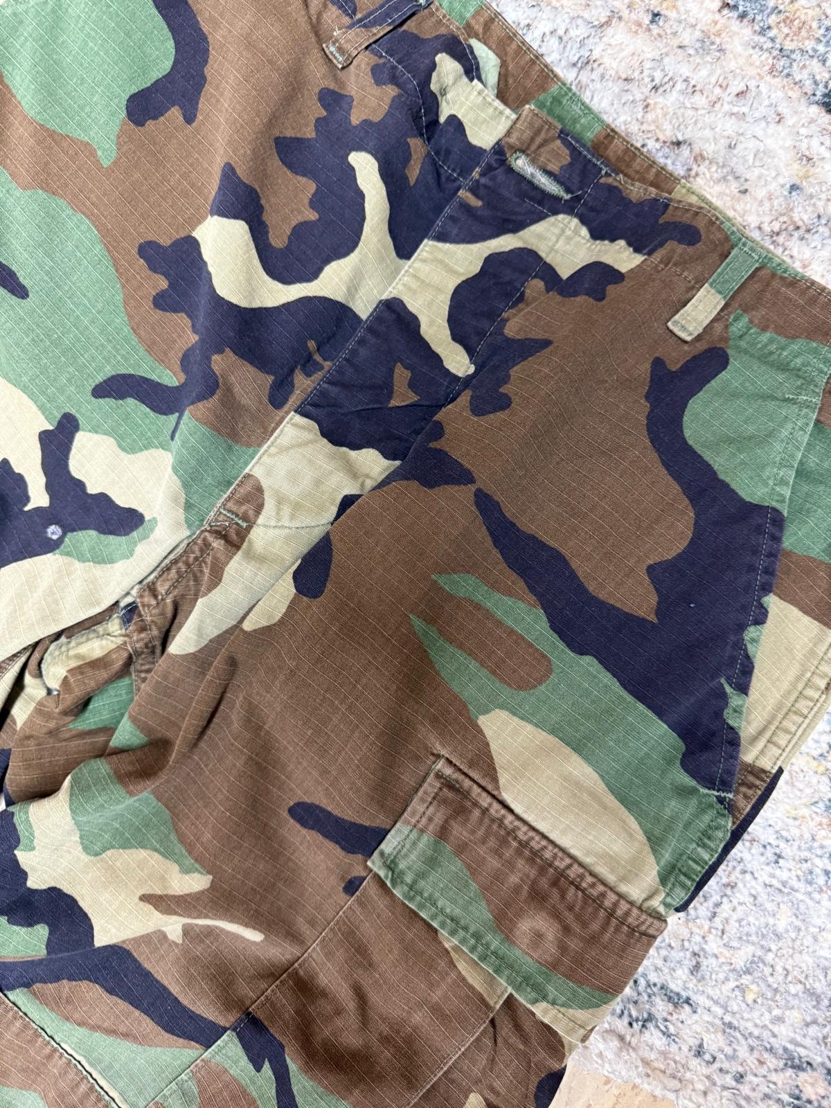 Camouflage pants folded and placed on a textured surface
