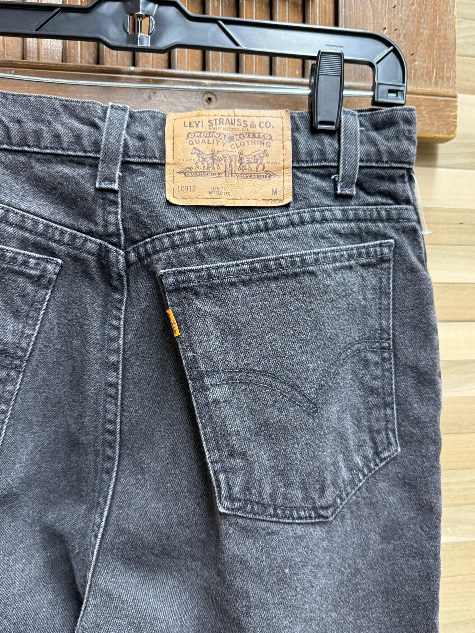 Black Levi's jeans with a tag on a wooden background