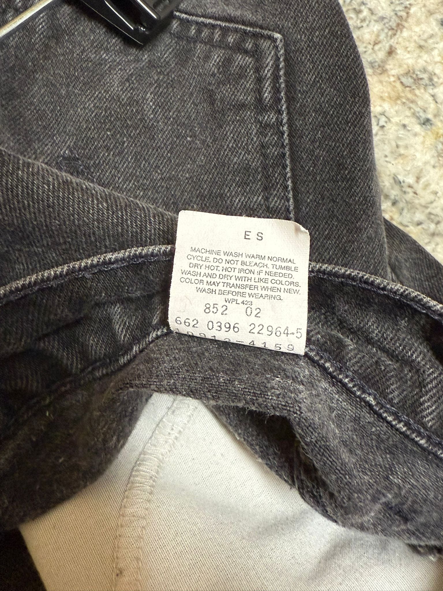 Close-up of a label on a piece of gray fabric with visible text.