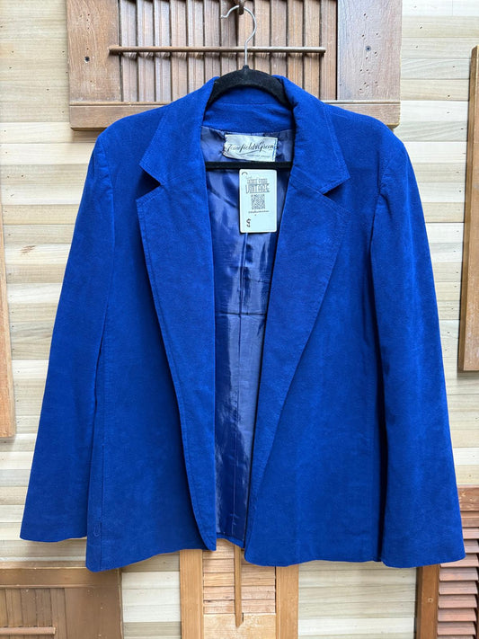 Blue suede jacket on a hanger against a wooden background